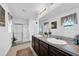 Main bathroom with double vanity, large mirror, and walk-in shower at 5557 Oro Valley Rd, Auburndale, FL 33823