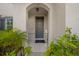 Front entry with gray door, arched entryway and landscaping at 5557 Oro Valley Rd, Auburndale, FL 33823