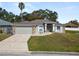 Single-story home with a two-car garage and landscaped yard at 5819 Driftwood Dr, Winter Haven, FL 33884