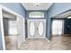 Bright entryway with double doors, wood-look floors, and views into adjacent rooms at 5819 Driftwood Dr, Winter Haven, FL 33884