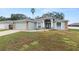 Landscaped yard with a single-story house featuring a gray exterior and stone accents at 5819 Driftwood Dr, Winter Haven, FL 33884