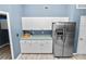 Kitchen features white cabinets and stainless steel refrigerator at 5819 Driftwood Dr, Winter Haven, FL 33884