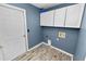 Laundry room with white cabinets and wood-look floors at 5819 Driftwood Dr, Winter Haven, FL 33884