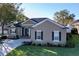 Tan house with dark shutters, landscaping, and a paved driveway at 5825 High Ridge Loop, Lakeland, FL 33812