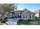 Tan house with dark shutters, lush landscaping, and a paved driveway at 5825 High Ridge Loop, Lakeland, FL 33812