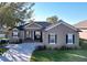 One-story house with a tan exterior, dark shutters, and a well-maintained lawn at 5825 High Ridge Loop, Lakeland, FL 33812