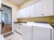 Bright laundry room with white cabinets, washer, and dryer at 5825 High Ridge Loop, Lakeland, FL 33812