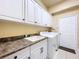 Laundry room with white cabinets, granite countertop, and washer/dryer hookups at 5825 High Ridge Loop, Lakeland, FL 33812