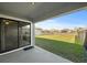 View of backyard from covered patio with sliding glass doors at 5876 Great Salt Ct, Lakeland, FL 33805