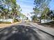 Welcoming entrance to Garden Grove Oaks, featuring mature trees and an American flag at 6087 Southern Oaks Se Dr, Winter Haven, FL 33884