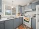 Bright kitchen with gray cabinets, white appliances, and a double sink at 6087 Southern Oaks Se Dr, Winter Haven, FL 33884