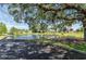 Picturesque community pond with a fountain, picnic tables, and mature trees providing shade at 6087 Southern Oaks Se Dr, Winter Haven, FL 33884