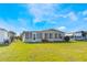 Tan house with screened porch and grassy yard at 6823 S Lake Henry Ne Dr, Winter Haven, FL 33881