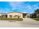 Tan single-story home with covered carport and landscaped yard at 6823 S Lake Henry Ne Dr, Winter Haven, FL 33881