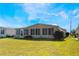 Back of tan mobile home overlooking a grassy yard at 6823 S Lake Henry Ne Dr, Winter Haven, FL 33881