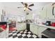 Eat-in kitchen with light green cabinets and black and white checkered floors at 7275 Lake Hendry Rd, Fort Meade, FL 33841