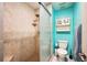 Bright teal bathroom with shower, toilet and built-in shelving at 781 Sagewood Dr, Lakeland, FL 33813