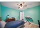 Teal bedroom with twin bed, ceiling fan and wood-look flooring at 781 Sagewood Dr, Lakeland, FL 33813