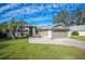 Green house exterior with a paved driveway and landscaping at 781 Sagewood Dr, Lakeland, FL 33813