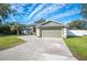 Green house with a two-car garage and a well-maintained lawn at 781 Sagewood Dr, Lakeland, FL 33813