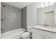 Modern bathroom with gray tiled shower, white fixtures, and granite countertop at 9419 Se 163Rd St, Summerfield, FL 34491