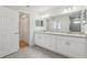 Bathroom with double sinks, granite counters, white cabinets and tile flooring at 9419 Se 163Rd St, Summerfield, FL 34491