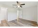 Spacious bedroom featuring wood-look flooring, ceiling fan, and ample natural light at 9419 Se 163Rd St, Summerfield, FL 34491