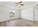 Spacious bedroom features a tray ceiling, ceiling fan and wood-look flooring at 9419 Se 163Rd St, Summerfield, FL 34491