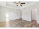 Spacious bedroom features a tray ceiling, ceiling fan and wood-look flooring at 9419 Se 163Rd St, Summerfield, FL 34491