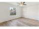 Cozy bedroom featuring wood-look flooring, ceiling fan, and a bright window view at 9419 Se 163Rd St, Summerfield, FL 34491