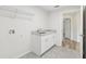 Bright laundry room features white cabinets, granite counters, sink and tile flooring at 9419 Se 163Rd St, Summerfield, FL 34491