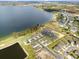 An aerial view of a community showcasing a large lakefront and newly built homes at 951 Craftsman Rd, Eagle Lake, FL 33839