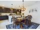 Open concept dining area featuring dark wood table, modern light fixture, and seamless flow into the kitchen at 951 Craftsman Rd, Eagle Lake, FL 33839