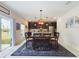 Bright dining area with sliding doors, an elegant wood table, and an open flow to the modern kitchen at 951 Craftsman Rd, Eagle Lake, FL 33839