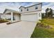 Two-story home with gray and white siding, a two-car garage, and manicured landscaping at 951 Craftsman Rd, Eagle Lake, FL 33839