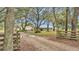 Long driveway leading to a charming ranch home with wooden fence at 9585 Shreck Rd, Bartow, FL 33830