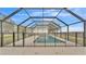 Enclosed pool area with a screened-in cage and a view of the countryside at 9585 Shreck Rd, Bartow, FL 33830