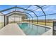 Enclosed pool with a screened-in cage and a view of the countryside at 9585 Shreck Rd, Bartow, FL 33830