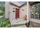 Quaint front porch with a red door and a rustic wooden deck at 1005 Shadow Run Dr, Lakeland, FL 33813