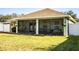 Home exterior showcasing a screened lanai with a grassy backyard and white vinyl fence at 1012 Robin Ln, Winter Haven, FL 33884