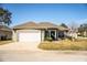 Green house with white garage door and well-manicured lawn at 1012 Robin Ln, Winter Haven, FL 33884