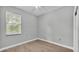 Simple bedroom with grey walls, wood-look flooring, and a window at 1033 Fleming Ave, Lakeland, FL 33815