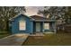 Newly constructed home with light blue exterior, driveway, and well-maintained lawn at 1033 Fleming Ave, Lakeland, FL 33815