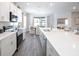 Modern kitchen with white cabinets, quartz countertops, stainless steel appliances, and an island at 1104 Mountain Flower Ln, Davenport, FL 33837