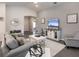 Living area with gray sofas, white accent pieces and a view of the kitchen at 1135 Aruba Ave, Mulberry, FL 33860