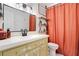 The bathroom features a white sink, a dark faucet, a large mirror, and a rust colored shower curtain at 1325 Fairlee St, Lakeland, FL 33813