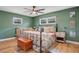 A bedroom with green walls, a ceiling fan, a bed with floral bedding, and two windows at 1325 Fairlee St, Lakeland, FL 33813