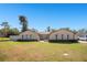 Stunning single-story home featuring arched windows, manicured landscaping, and a sprawling green lawn at 1325 Fairlee St, Lakeland, FL 33813