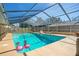 Backyard pool with a screened enclosure, clear water, and playful pink flamingo floats at 1325 Fairlee St, Lakeland, FL 33813