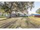 Large grassy backyard with a mature tree providing ample shade and privacy at 1495 Davis Ave, Bartow, FL 33830